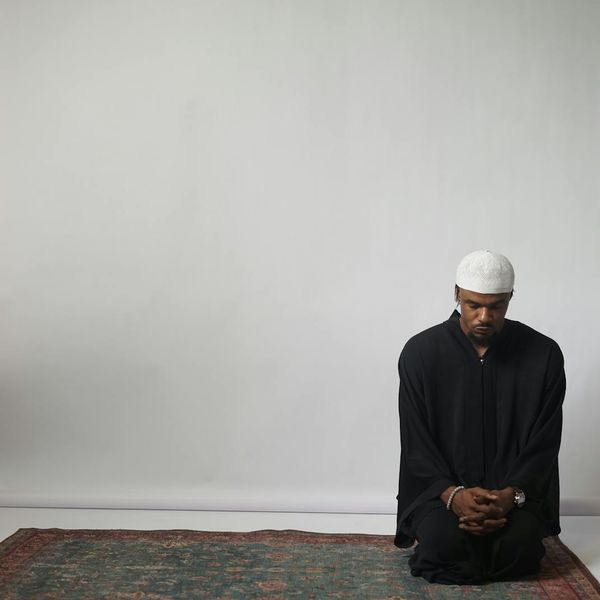 Person meditating peacefully in a calm, minimalist setting.