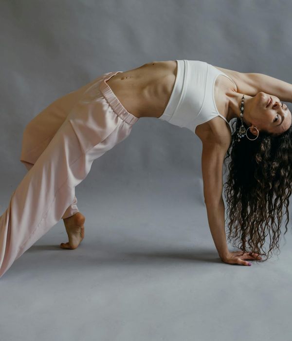 Woman in a fluid yoga pose, demonstrating flexibility and control.